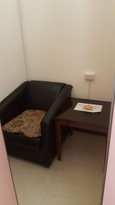 林口本部哺乳室內部空間，配置黑色單人沙發椅與小桌子，營造隱密舒適的使用環境。圖片