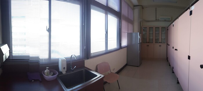 林口本部哺乳室公共空間，設有流理台、冰箱、椅子與個別隔間，光線明亮寬敞整潔。圖片